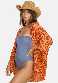 Kimono de estampado naranja sobre un bañador de una pieza de rayas azules, con un sombrero de paja de ala ancha. Colores brillantes y diseño fluido.