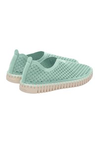 Coppia di scarpe slip-on verde menta con tomaia traforata e suole in gomma beige chiaro cucite, viste da un angolo laterale posteriore.