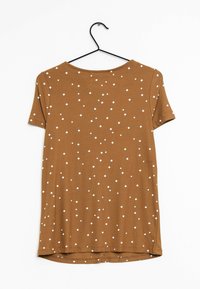 Braunes T-Shirt mit kurzen Ärmeln, das weiße, diamantförmige Punkte aufweist. Es besteht aus weichem Stoff, hat einen runden Halsausschnitt und einen abgerundeten Saum.