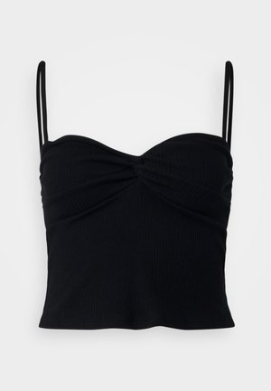 Zwarte geribbelde crop top met een sweetheart-halslijn, gedraaide voorkant en dunne verstelbare bandjes. Zachte, rekbare stof.