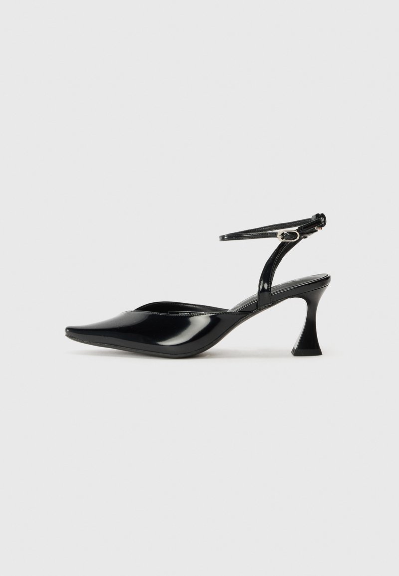 Černé lakované slingback boty s špičatou špičkou a unikátně tvarovaným podpatkem. Obsahuje tenký páskový řemínek kolem kotníku s malou stříbrnou přezkou.