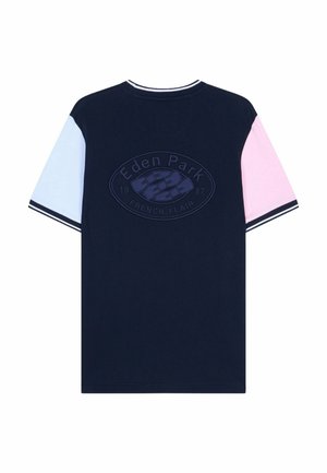 T-shirt bleu marine avec manche gauche bleu clair, manche droite rose, col et poignets à rayures, et logo embossé "Eden Park French Flair 1987" au dos.