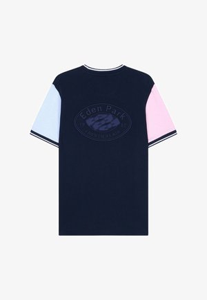 T-shirt bleu marine avec manche gauche bleu clair, manche droite rose, col et poignets à rayures, et logo embossé "Eden Park French Flair 1987" au dos.