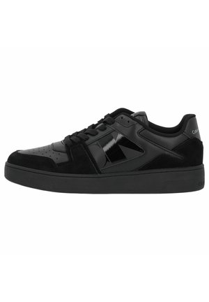 Sneaker nere con un mix di texture lucide e scamosciate, punta tonda, design con lacci, suola in gomma nera opaca e branding minimale.