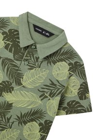 Polo verde con colletto, caratterizzato da un motivo a foglia di verde chiaro su uno sfondo verde scuro. Realizzato in tessuto morbido e strutturato.