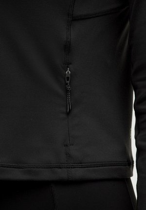 Haut de sport zippé noir avec une texture lisse, doté d'une courte fermeture éclair et de coutures renforcées le long des seams.