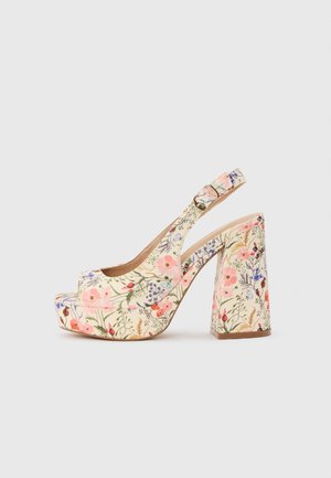 Plateauzool sandaal met hoge hak, enkelsbandje en gesp, met een bloemenpatroon in roze, paars en groen op een crèmekleurige achtergrond.