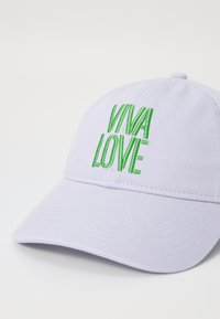 Gaiši violeta beisbola cepure ar zaļu izšūtu tekstu "VIVA LOVE" priekšpusē. Ievērojama ar izliekto vizieri un teksturētu audumu.