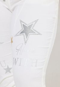 Witte leggings met metalen zilveren en gouden sterontwerpen, met de tekst "Altijd BIJ JOU," versierd met sprankelende rhinestones.