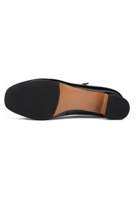 Semelle d'une chaussure habillée noire montrant un talon en caoutchouc noir et des zones antidérapantes à l'avant-pied avec une section intermédiaire en cuir lisse couleur fauve.