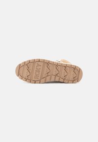Beżowa podeszwa sneakersów z teksturowanym gumowym gripem, z wzorem w zygzaki i wytłoczonym logo "ROXY". Solidna konstrukcja zapewniająca trwałość.