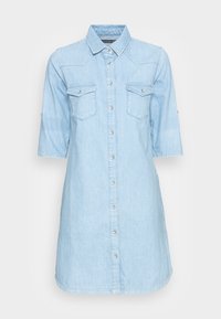 Světle modré denimové šaty s knoflíkovým zapínáním vpředu, špičatým límcem, náprsními kapsami a krátkými rukávy. Mají rovný střih s bočními rozparky.