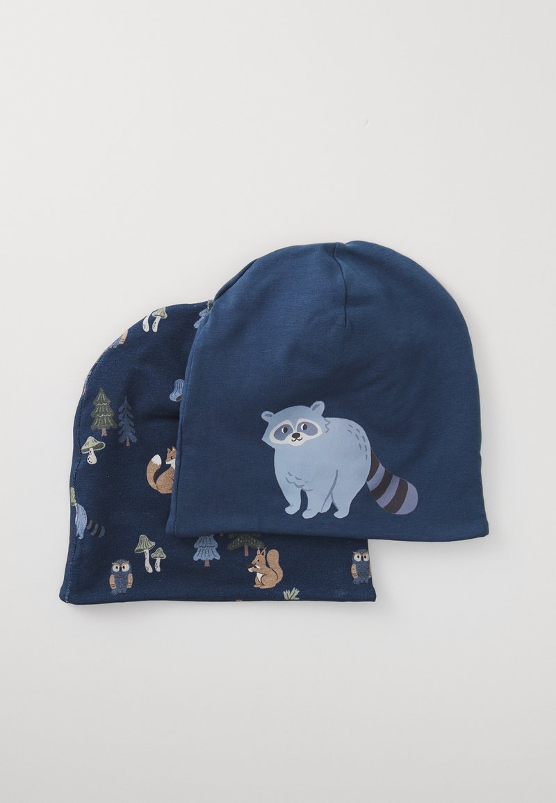 Twee marineblauwe beanies van zachte stof. De ene heeft een grafiek van een blauwe wasbeer; de andere heeft een patroon van bosdieren met bomen en paddenstoelen.