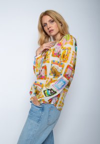 Mehrfarbige gemusterte Bluse mit langen Ärmeln und lockerer Passform, aus leichtem Stoff, mit floralen und abstrakten Designs.