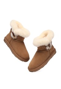 Brown suede ankle boots with a soft, white fur lining, featuring a strap on the side, rounded toe, and a textured rubber sole.