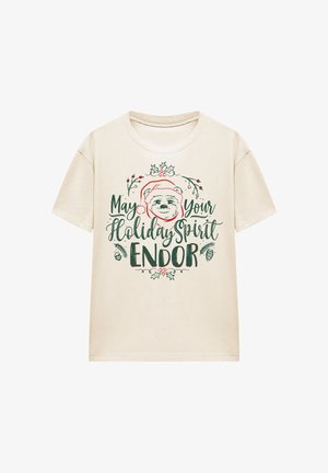 Beige T-Shirt mit festlichem Design eines Bären, der einen Weihnachtsmannhut trägt, umgeben von Stechpalmen, Beeren und Tannenzapfen, mit dem Text "Möge Ihr Feiertagsgeist erstrahlen".
