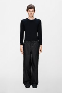 Μαύρο μπλουζάκι με μακριά μανίκια και άνετο μαύρο παντελόνι cargo με ελαστική μέση, που διαθέτει πλαϊνές τσέπες και λεία, ματ υφή.