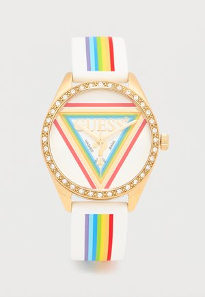 Montre dorée avec lunette en cristal, bracelet blanc orné de rayures verticales arc-en-ciel, cadran avec triangles multicolores et logo "GUESS".