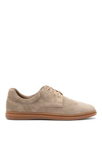 Zapato de ante beige con textura perforada, puntera redonda, diseño de cordones y suela de goma marrón, con detalles de costura mínimos.