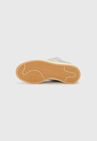 Light blue sneaker with a textured rubber outsole, featuring zigzag patterns, and a smooth, matte upper material.