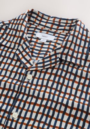 Chemise à manches courtes à carreaux en blanc, marine et rouille. Tissu en coton avec col, présentant un motif à carreaux et une fermeture boutonnée sur le devant.