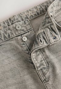 Grijze denim jeans met een vervaagde afwerking. Kenmerkt metalen knopen, een knopenfly en versleten accenten bij de taille. maatlabel "34R".