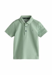 Polo tričko ze světle zelené bavlny. Má límeček, krátké rukávy, zapínání na tři knoflíky a vyšívanou nášivku na levé části hrudi.