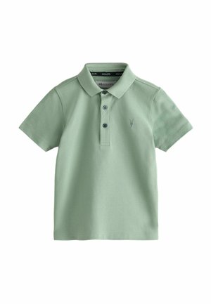 Koszulka polo w jasnym zielonym kolorze z bawełny. Posiada kołnierzyk, krótkie rękawy, zapięcie na trzy guziki oraz haftowany emblemat na lewej piersi.