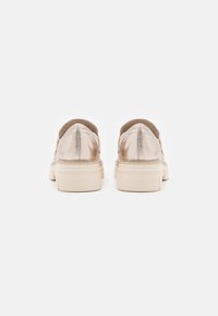 Metallic gold Sneakers mit einer strukturierten Oberseite und beigen Gummisohlen. Besitzt eine abgerundete Form und ein minimalistisches Design, geeignet für die Freizeit.
