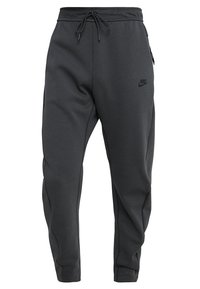 Nike-joggers i mörkgrått, med dragsko i midjan, sidofickor och en subtil logotyp framtill. Slät tyg med avsmalnande ben.