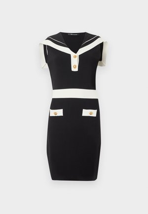 Svart ermeløs kjole til kneet med hvit sjømannskrage, hvitt midjebelte, to frontlommer og gullknapper på kragen og lommene.