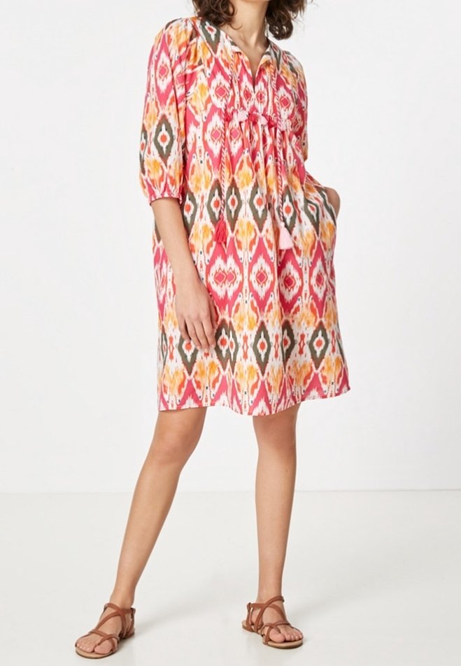Robe colorée mi-longue avec un col en V, devant froncé, manches trois-quarts, motif géométrique rose et orange, dotée de deux poches latérales.