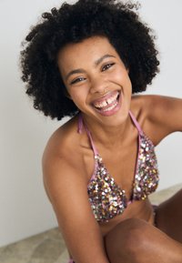 Pailletten bikini i nyanser av rosa og flerfarget, med en trekantet bralette-design, tynne stropper og en jevn tekstur.