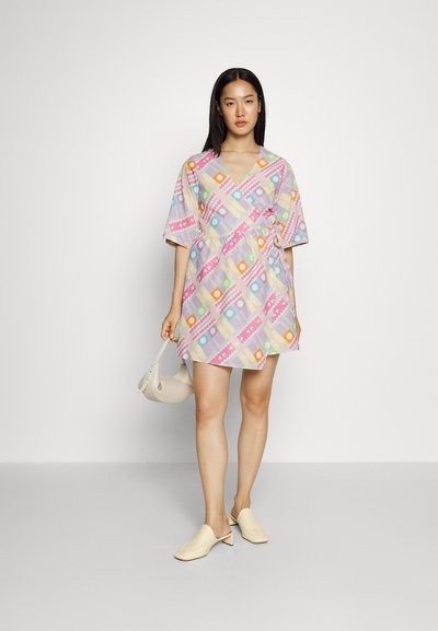 Vestido de manga curta, estilo envolvente, em cores pastel com padrões geométricos. Apresenta decote em v, cintura ajustada e silhueta fluida.