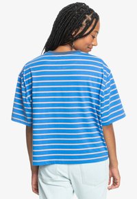 Blue striped t-shirt with short sleeves, featuring horizontal stripes in light pink. The shirt has a relaxed fit and a crew neckline.