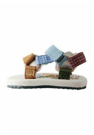 Sandale enfant avec des brides en tissu multicolores en moutarde, bleu, bleu clair, vert et bordeaux sur une semelle beige avec une semelle extérieure noire.