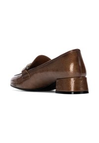 Mocasines de cuero marrón con acabado brillante, tacón bajo y una tira decorativa en la parte superior. Textura suave y forma de punta redondeada.