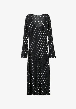 Black long-sleeve midi dress with white polka dots and a scoop neckline, slightly fitted at the waist.