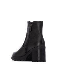 Bota de tobillo de cuero negro con punta redondeada, cremallera lateral y tacón de bloque texturizado. Cuenta con suela de goma para mayor tracción.