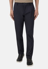 Tumed sinised püksid kitsas lõikes, millel on lapik esiosa, vöölõngad ja lukuga tõmblukk. Komponendiks mustad tossud hallide aktsentidega.