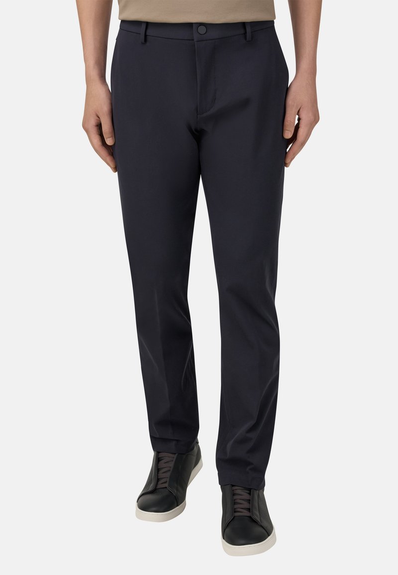 Tumed sinised püksid kitsas lõikes, millel on lapik esiosa, vöölõngad ja lukuga tõmblukk. Komponendiks mustad tossud hallide aktsentidega.