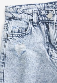 Helles, blaues Jeansshorts mit einem ausgefransten herzförmigen Riss an der Vorderasche, mit einem Metallknopf und gesticktem Bund.