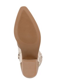 Beżowa podeszwa buta o gładkim, lekko spiczastym kształcie. Teksturowana powierzchnia z poziomymi rowkami dla lepszej przyczepności. Solidny materiał gumowy.