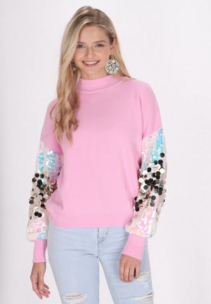 Maglione rosa con collo alto e maniche lunghe, decorato con applicazioni di paillettes colorate. Il materiale sembra morbido e ha una vestibilità comoda.