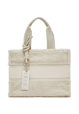 Borsa a mano rettangolare color crema con tessuto morbido e strutturato, manici spessi e una targhetta del marchio sospesa attaccata a un manico.