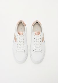 White sneakers with a smooth texture, featuring metallic rose gold and silver stripes, six lace holes, and a cushioned insole.