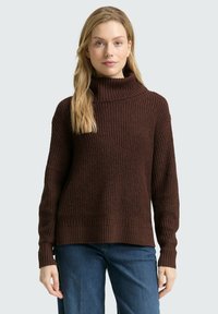 Brauner gestrickter Pullover mit hohem Rippkragen und langen Ärmeln. Hat ein strukturiertes Muster und eine lässige Passform. Kombiniert mit Jeans.