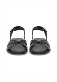 Sandalias negras con suela plana, con diseño de tiras cruzadas, correa en el tobillo con hebilla y material de cuero suave.
