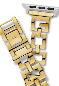 Bransoletka z metalicznego złota z połączonymi geometrycznymi ogniwami, z polerowanym wykończeniem i srebrnym akcentem z nazwą marki "GUESS."