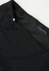 Prenda negra con tejido texturizado de superficie suave, cintura lisa y una etiqueta con el logo que dice "TEZENIS".